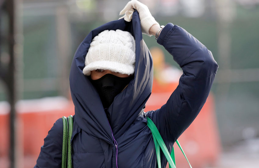 Commuters braces against the cold on crosses Michigan Avenue on